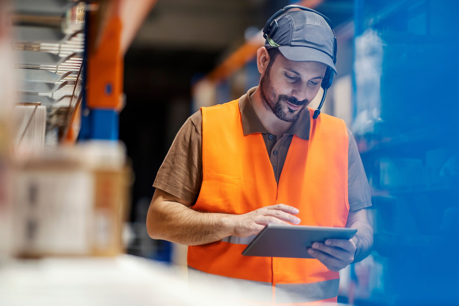A post express worker checking on shipment on tablet.