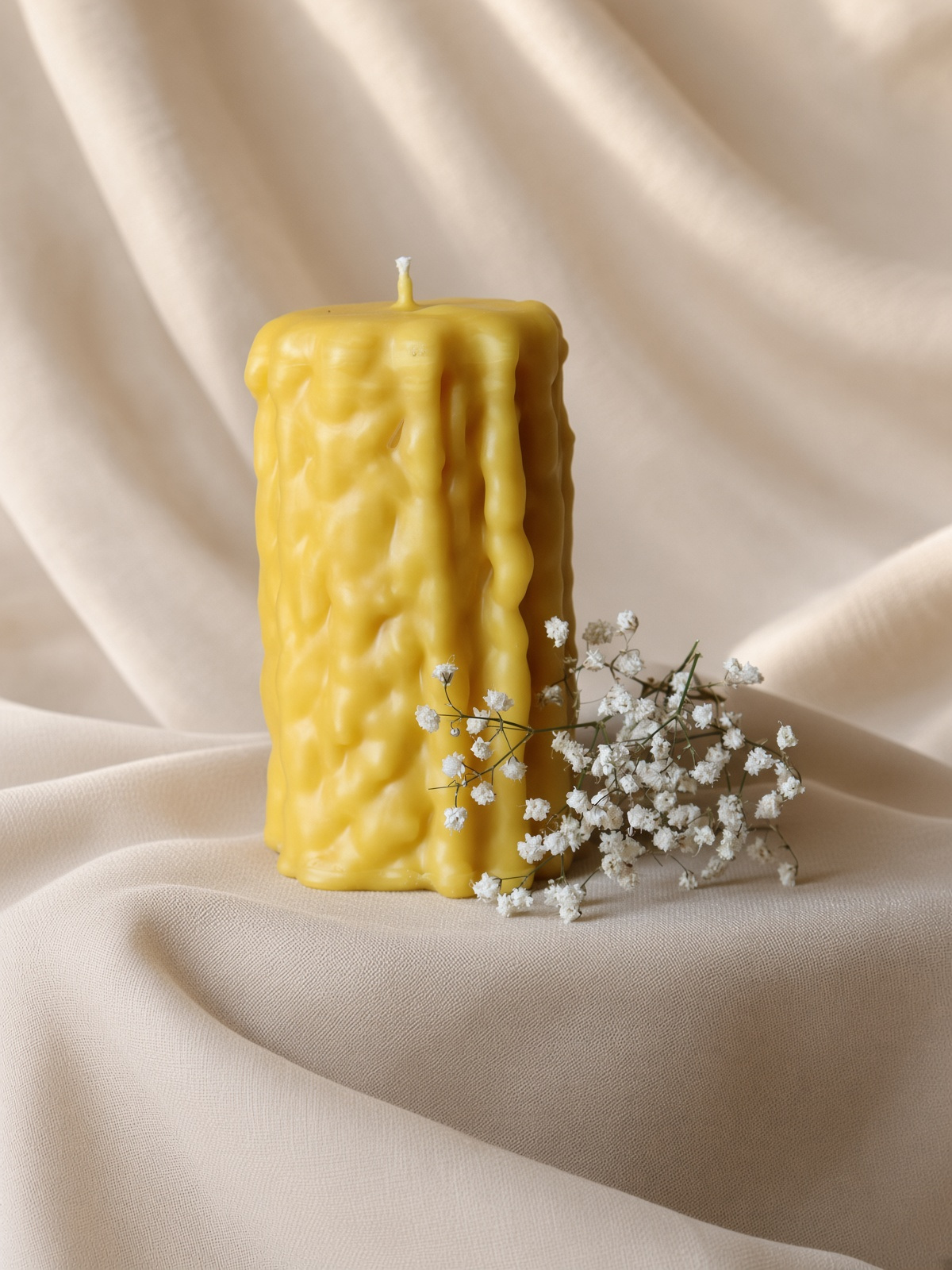 A studio-lit beeswax pillar on a table