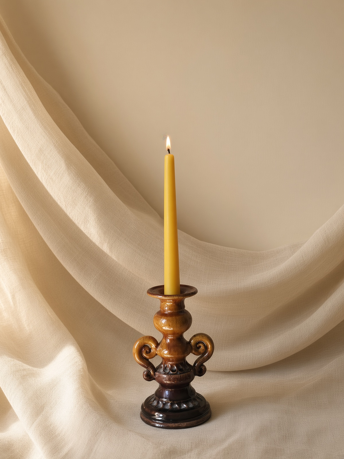 Lit beeswax tapers on a table